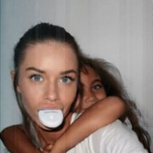 Woman wearing the BrighterWhite LED light while being hugged from behind